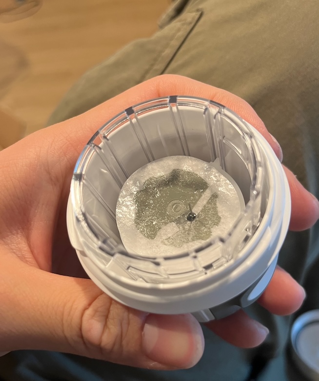 Looking into the round spring-loaded Stelo applicator held in hand, sensor visible at the bottom