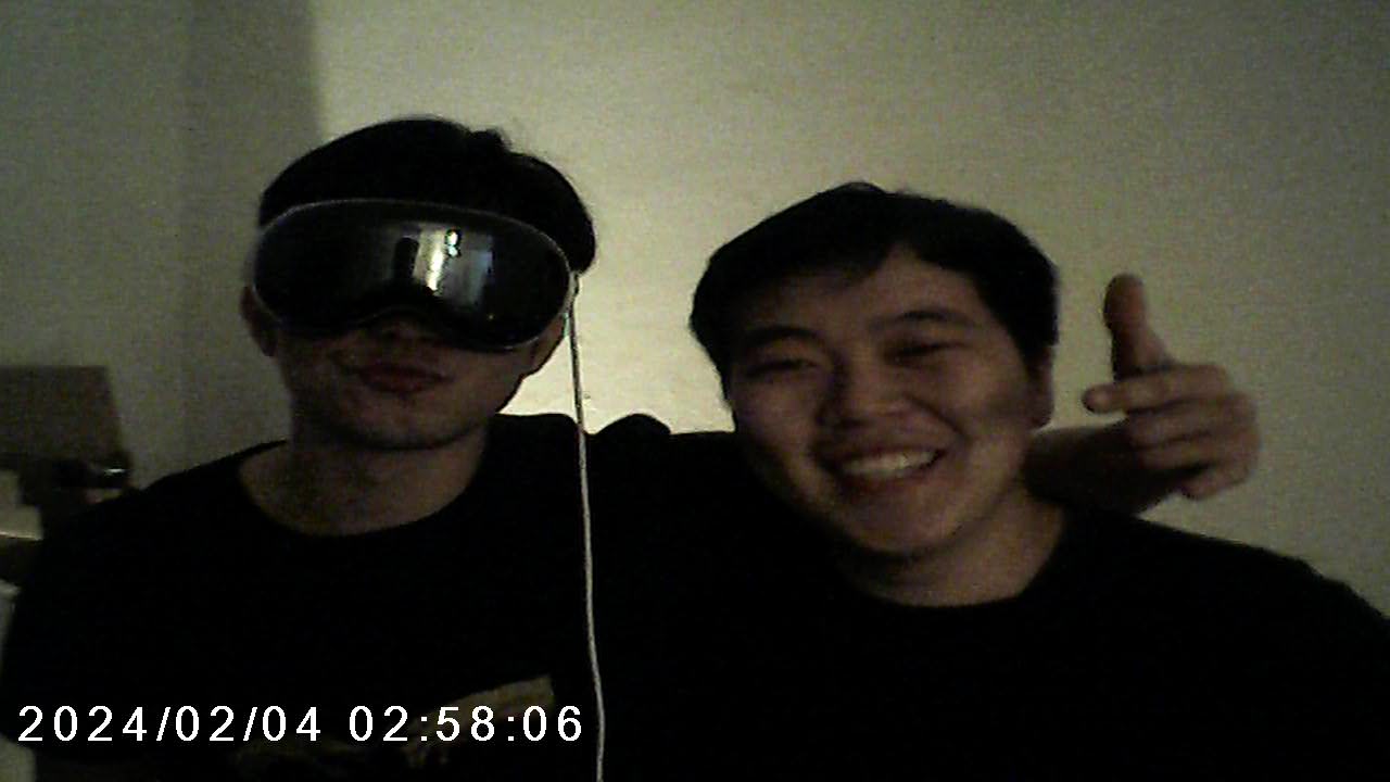 Grainy timestamped toy camera photo of two friends, one wearing a VR headset and the other grinning