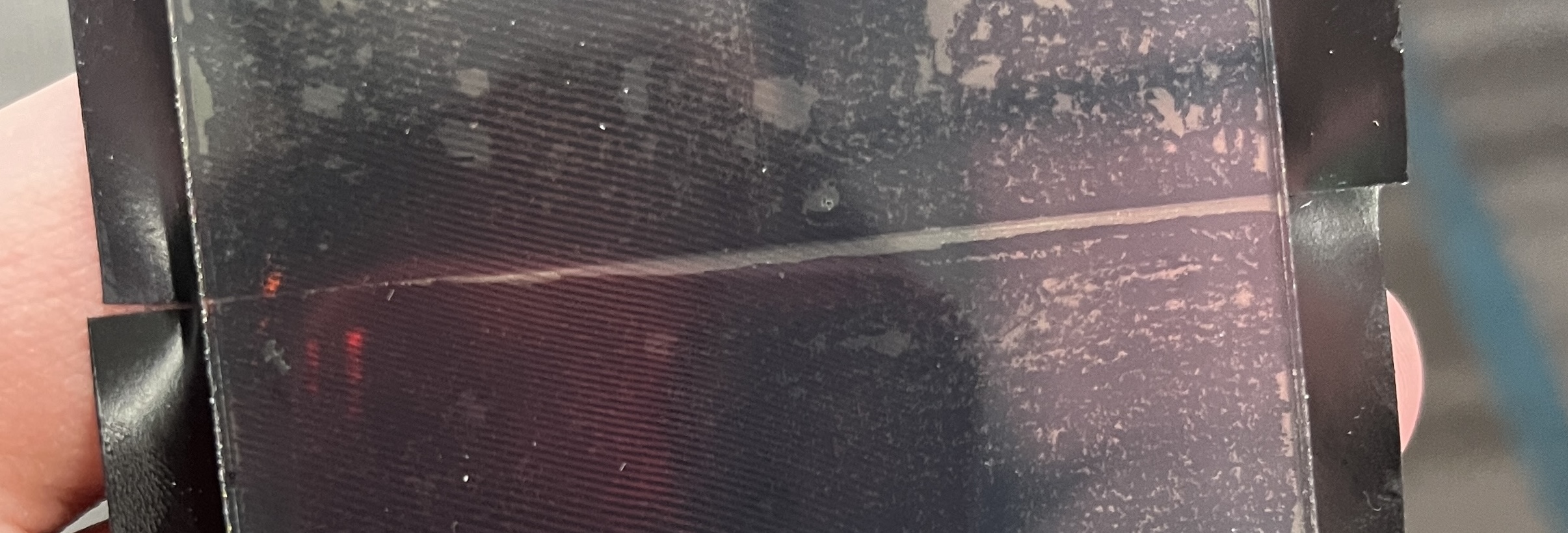 Close-up of the hologram plate showing the visible seam ridge where overlapping tape pieces meet