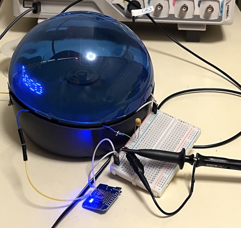Infoglobe wired to a breadboard and ESP8266, with oscilloscope probes attached for testing