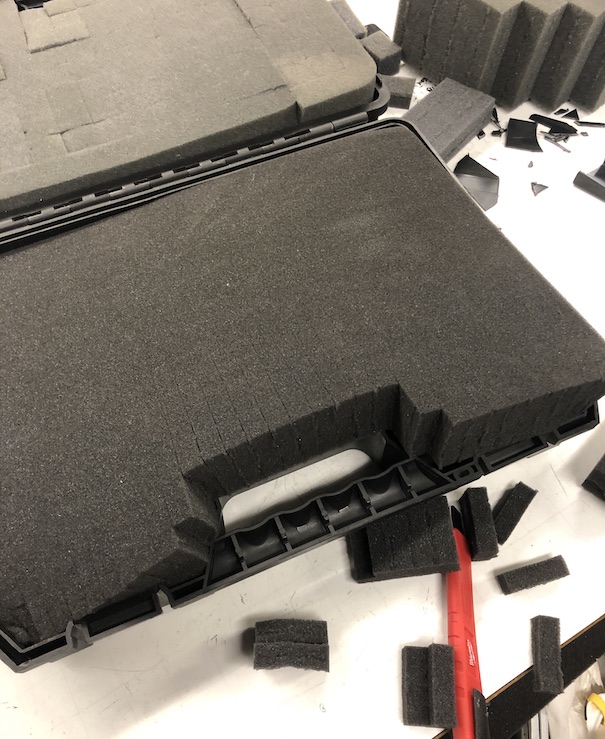 Open case with pluck-and-pull foam being trimmed to hold the two counters