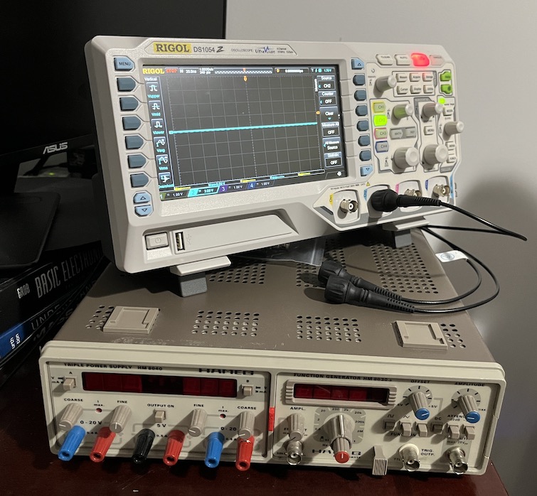 Rigol oscilloscope stacked on top of a Hameg triple power supply and function generator