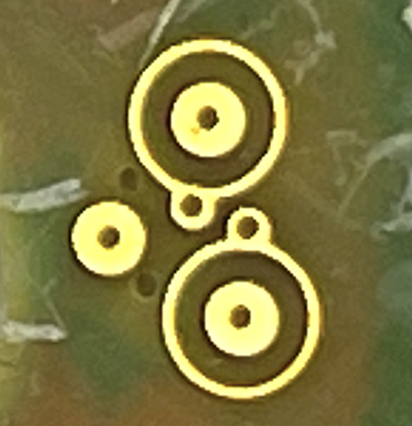Gold needle contact pads on the PCB, each encircled by a guard ring