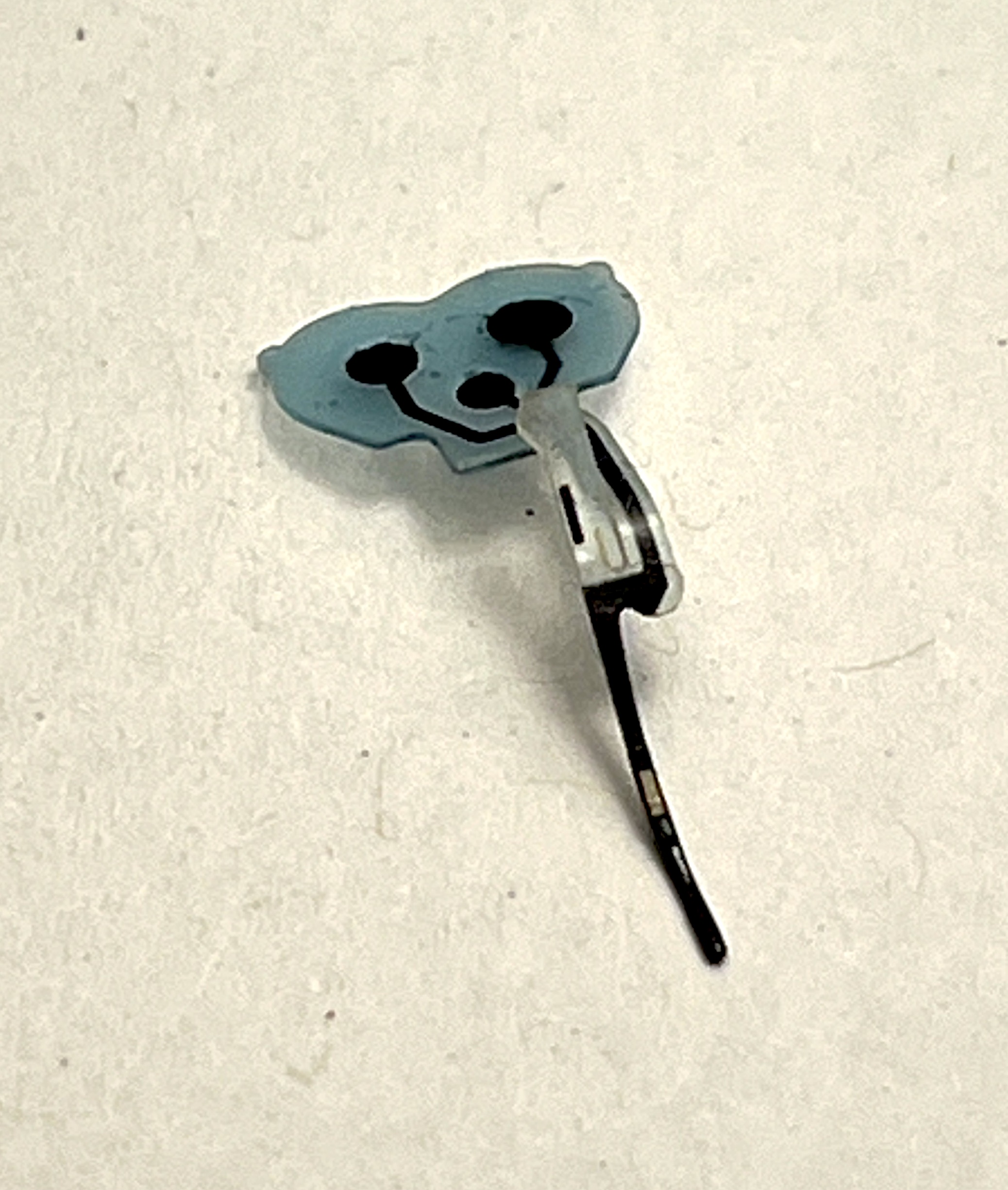 Needle assembly close-up showing the rubbery black contact dots with tiny holes on their surfaces