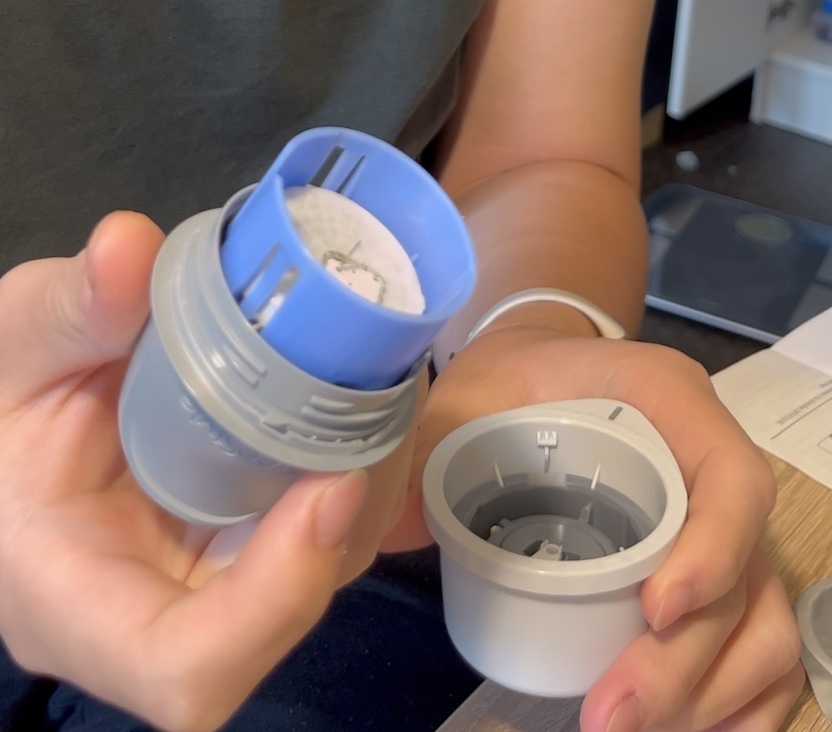 Hands holding the two applicator pieces that click together to load the sensor needle-side out