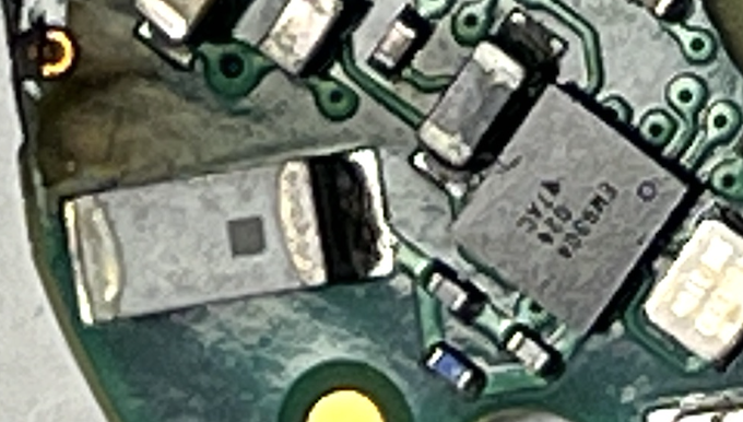 Blurry close-up of the unidentified chip suspected of providing Bluetooth, next to its antenna and clock