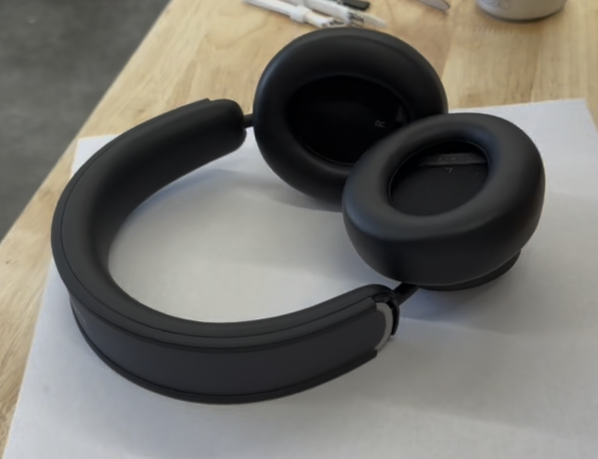 Black Urbanista Los Angeles headphones lying on a paper-covered workbench before disassembly