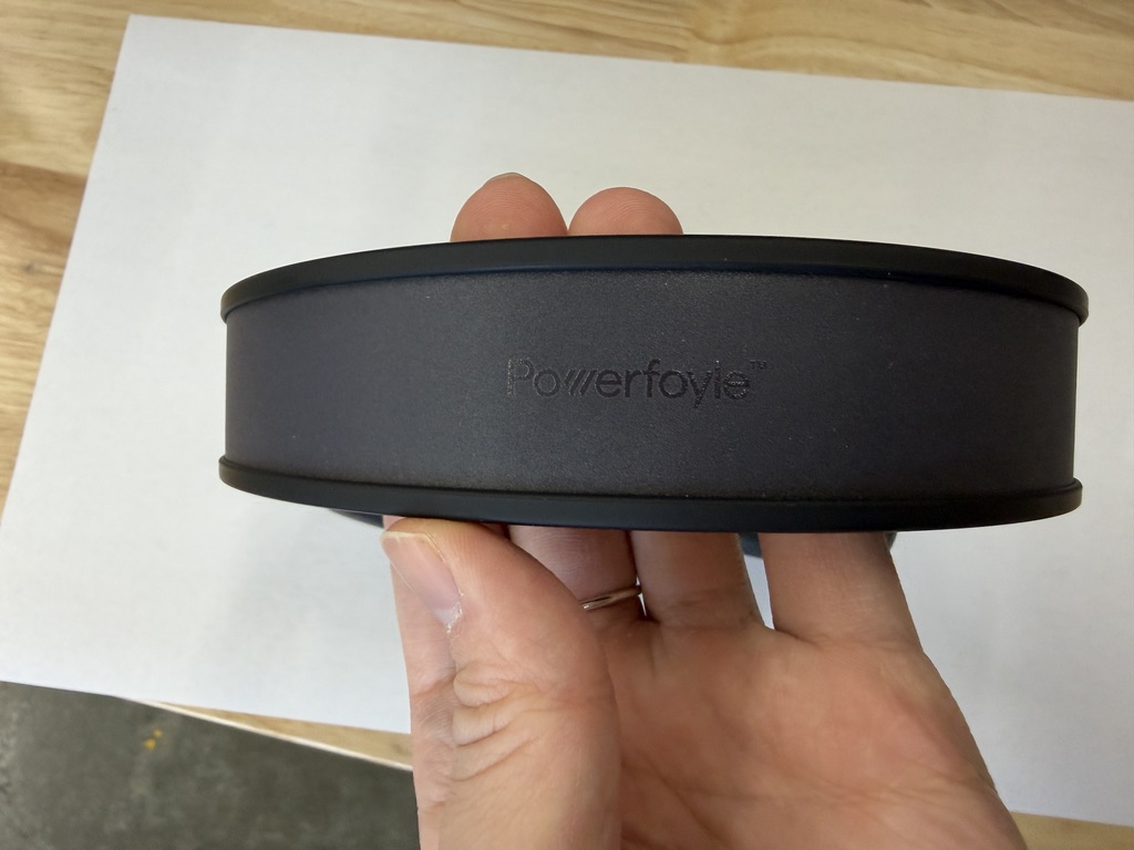 Hand holding the top band with the Powerfoyle logo engraved on the built-in solar panel