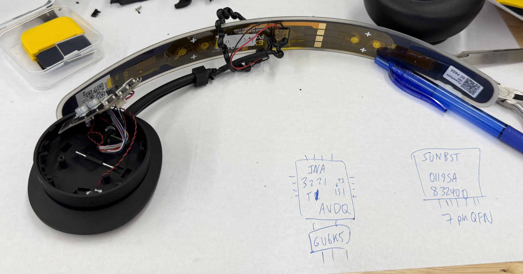 Opened right earcup and solar band beside handwritten notes of chip markings, including the SUNBST harvester